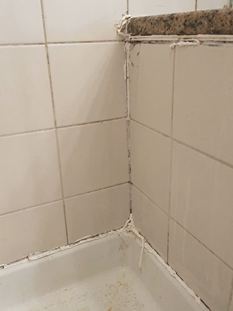 Before bathtub corner re-caulking in Richmond Hill.