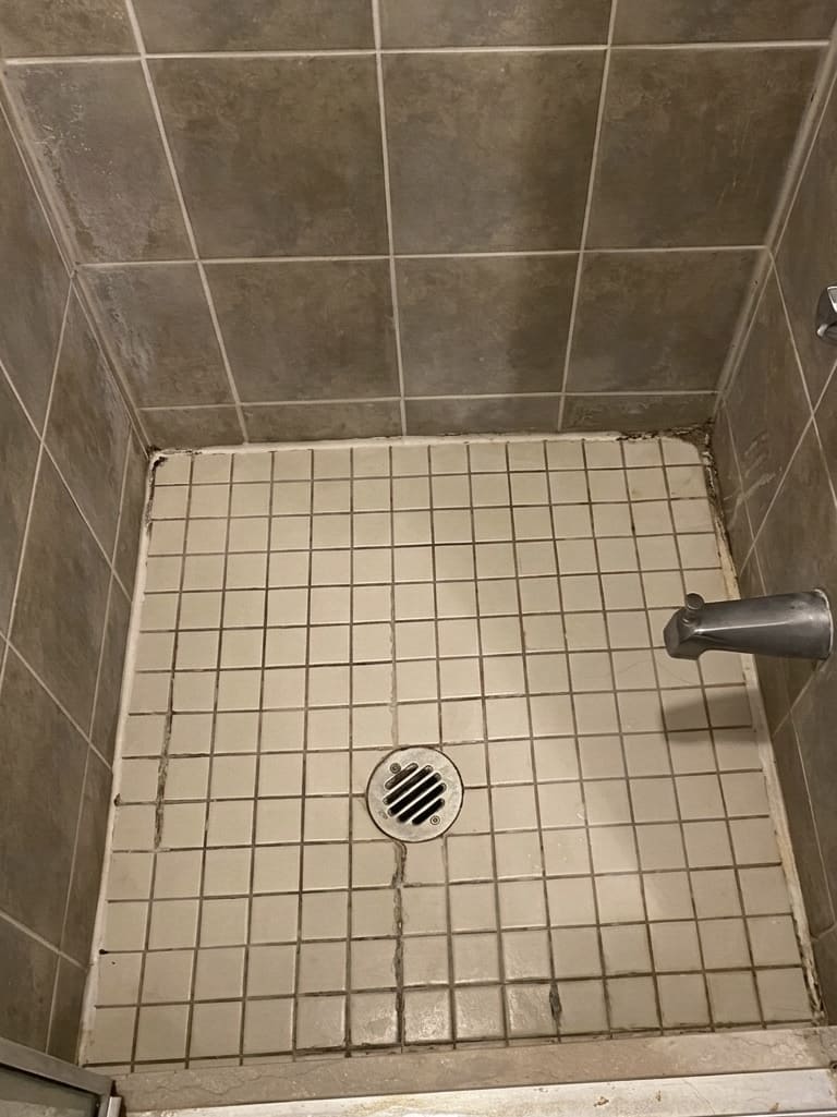 Before shower floor corner re-caulking in Toronto.