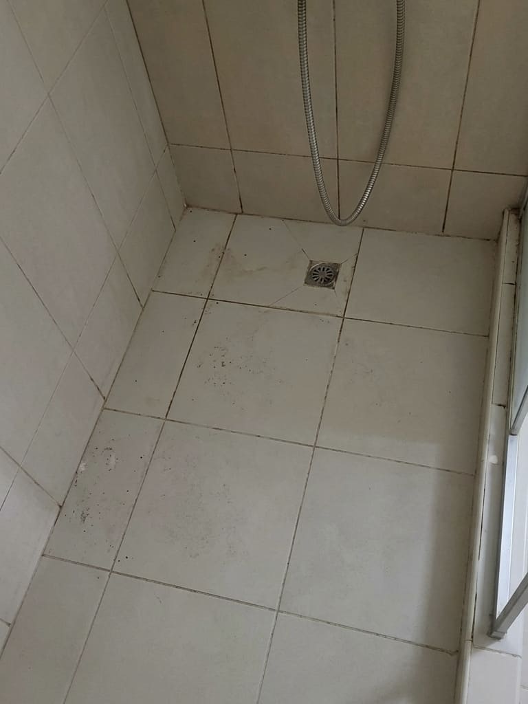 Before shower floor perimeter re-caulking in Toronto.