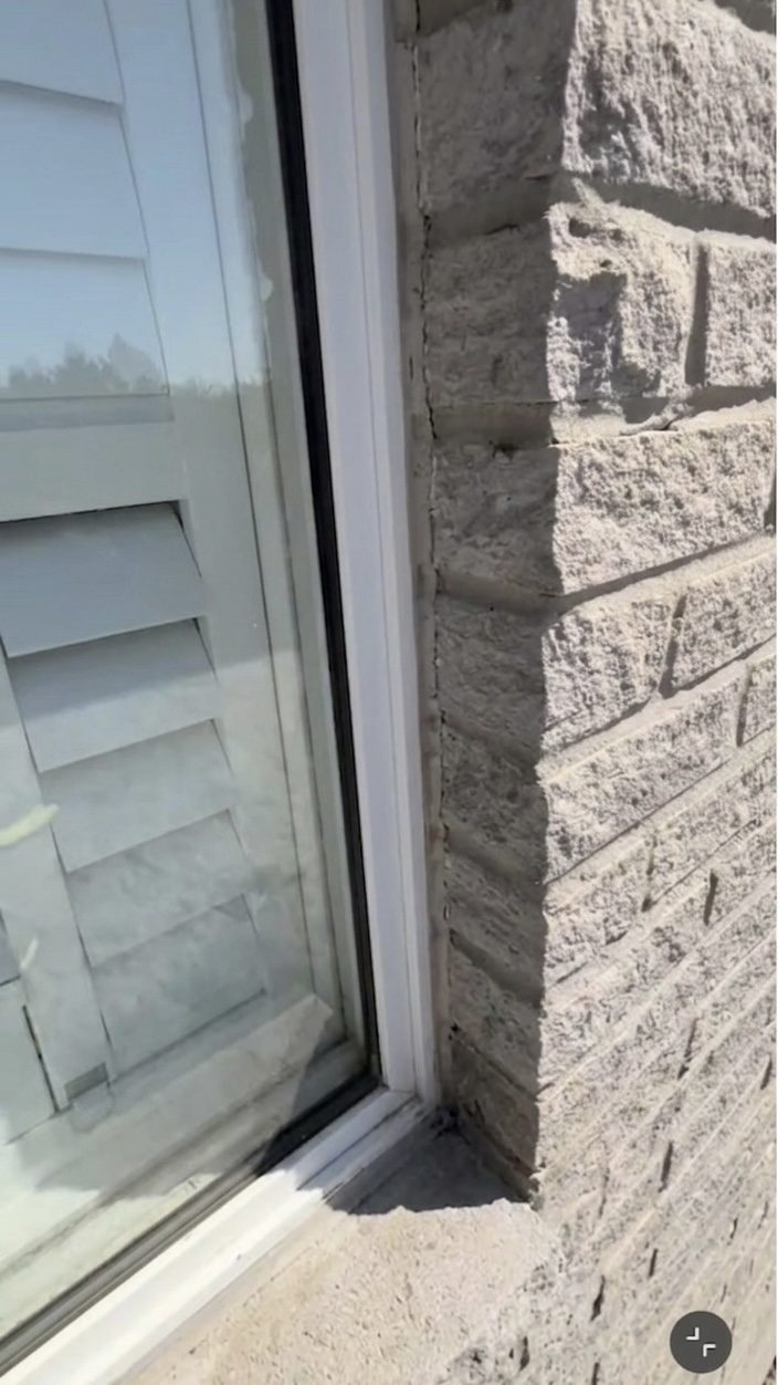 Cleaning the joint between the window frame and facade in Etobicoke before applying silicone